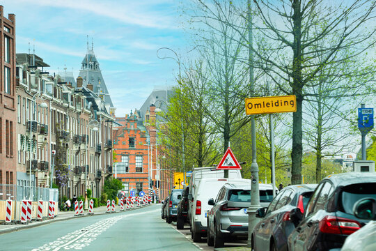 Yellow road sign reading Omleiding (Detour) due to roadworks on a street in Amsterdam (Amsterdam), Netherlands