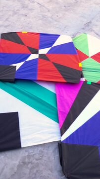 Colorful geometric kites in various designs lying on rough concrete ground kite color design pattern