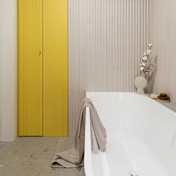 Modern Bathroom Interior with Vibrant Yellow Cabinetry, White Bathtub, and Neutral Textured Tile Walls for Home Decor