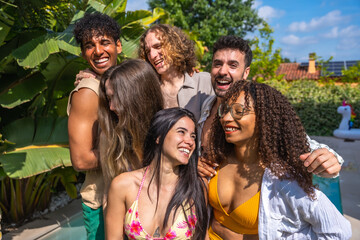 Fototapeta premium Diverse friends laughing and hugging at summer pool party