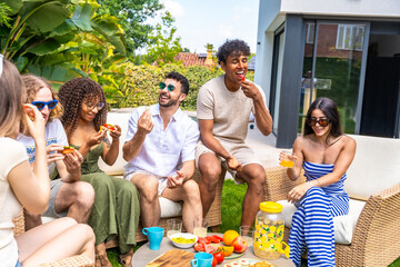 Diverse friends sharing food and drinks at outdoor summer party