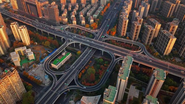 Aerial shot of complex freeway interchange with flowing traffic in Hangzhou, China during sunset.