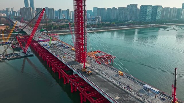 Aerial view of a large bridge over the river is in the process of being dismantled using cranes.