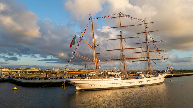 Aerial view of the tall ship NRP Sagres decorated with signal flags navigating the Canal de Aveiro near the salt pans Aveiro, Aveiro, Portugal.
