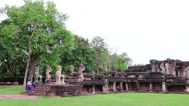 Female traveler walking up ancient Naga bridge at Phimai Historical Park, Nakhon Ratchasima, Thailand