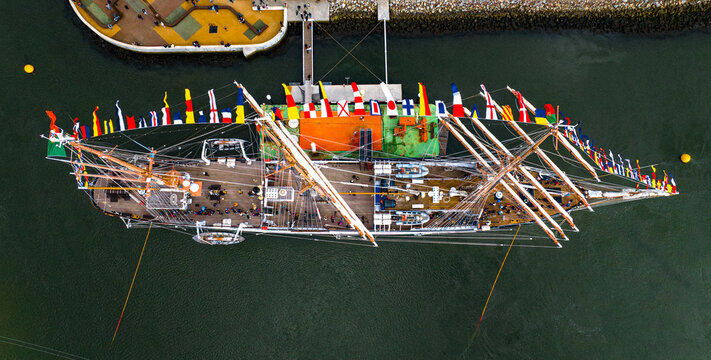 Aerial view of the tall ship NRP Sagres decorated with signal flags navigating the Canal de Aveiro near the salt pans Aveiro, Aveiro, Portugal.