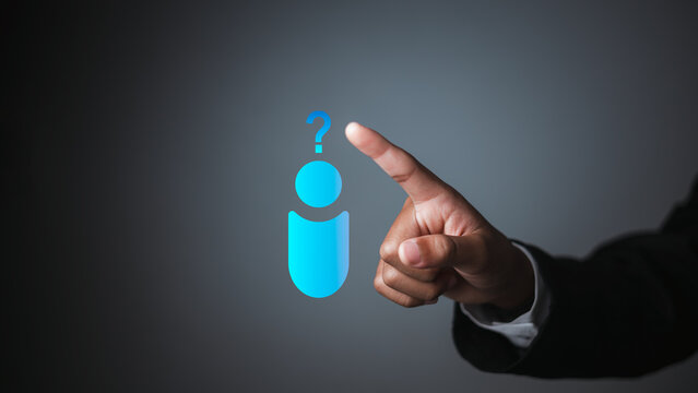 Close up of businessman hand pointing at virtual human icon with question mark. Concept of customer support, finding solutions, human resources FAQ, and problem solving in business.