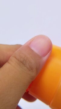 Closeup of hand removing cap from cosmetic cream tube. Vertical footage for beauty product unboxing and packaging content.