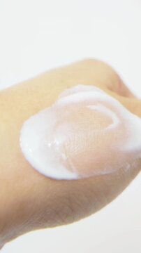 Applying white cream gently and showing it from close up. Soft moisturizing texture, skincare routine for smooth healthy skin.