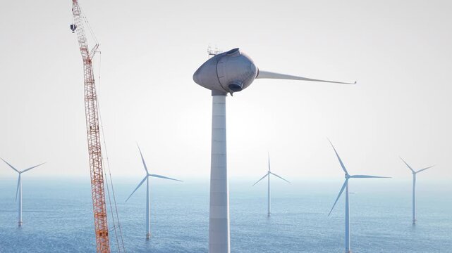 Wind turbine construction with a huge crane at a wind park in Flevoland Netherlands. Aerial view drone photo from above.