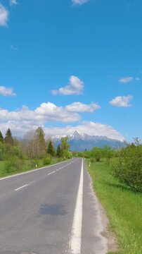 Scenic view while driving on a rural asphalt road towards the majestic krivan peak in slovakia