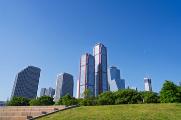 Fototapeta premium Modern Skyscrapers and Office Buildings with Green Trees in Seoul under Blue Sky