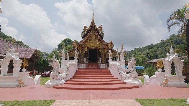 The image shows the facade of Wat Tat Muey Wanaram, a temple in Chiang Mai Province, Thailand, which displays Lanna art and culture, including a white Naga serpent staircase.