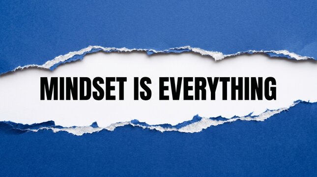 Mindset is everything text written on a white paper strip revealed through a torn blue cardboard frame in this conceptual high contrast studio photography shot