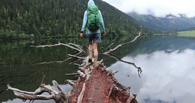 Hiking woman on a one plank bridge in high altitude mountains