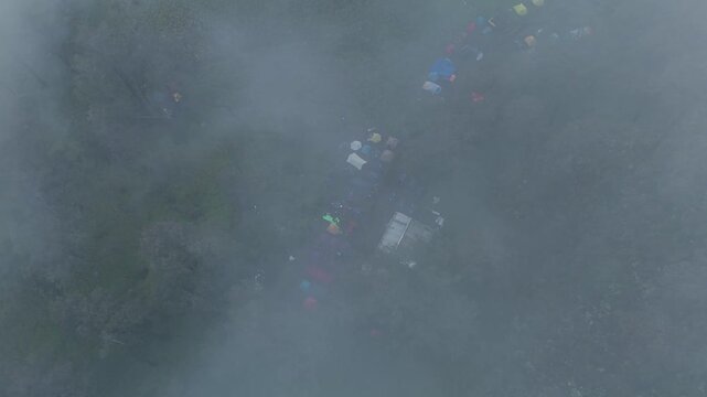 A Majestic Aerial View of Colorful Tents Living in Harmony with Fog-Covered Nature Lawu Central Java