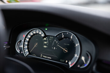 Naklejka premium Dashboard display of a modern vehicle showing speedometer, fuel gauge, and temperature indicator with digital readouts and illuminated symbols