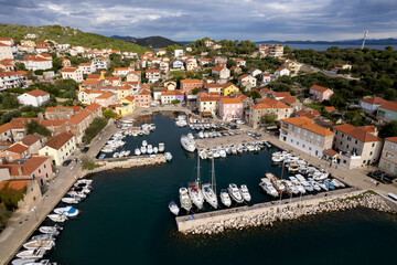 Obraz premium Aerial view of yachts and boats docked in Sali marina, Dugi Otok island, Croatia. Drone shot of beautiful mediterranean port filled with luxury yachts during sunrise.