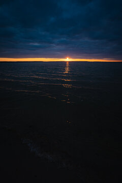 Sunset on the lake. Evening sky with beautiful clouds is reflected in the water of the lake