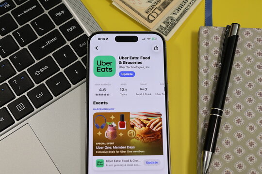 Kiel, Germany - 05-20-2026: Smartphone displaying the Uber Eats Food delivery and grocery shopping app in the App Store in a workspace environment with laptop and notebook