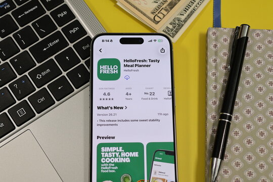Kiel, Germany - 05-20-2026: Smartphone displaying the HelloFresh: Tasty Meal Planner meal planning and grocery delivery app in the App Store in a workspace environment with laptop and notebook