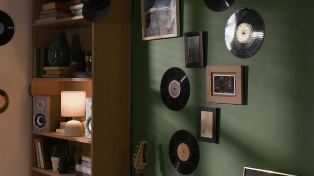 Tilt down shot of framed gold record plaque displayed on shelf in musicians cozy apartment with vinyl wall decor