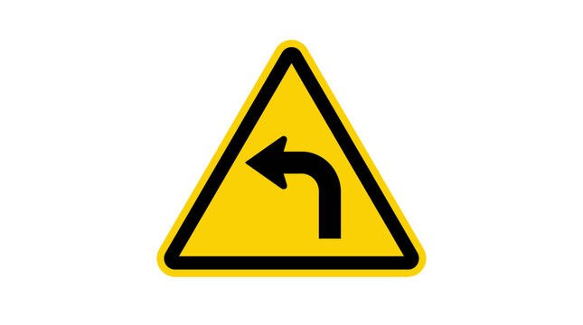 A yellow triangular warning sign indicating a sharp left turn ahead on the road.
