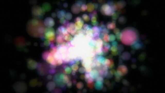 黒背景に中央から飛び散る光の粒