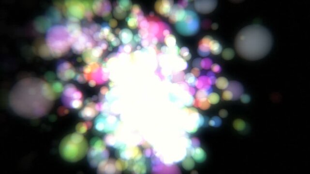 黒背景に左から飛び散る光の粒