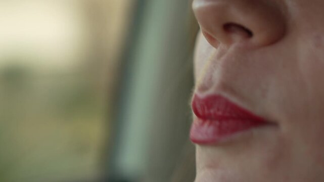 Lipsticks makeup application woman applying bright red color to her lips while sitting in a car for a glamorous look