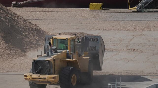 Heavy machinery loads cargo at busy shipping dock during daylight hours