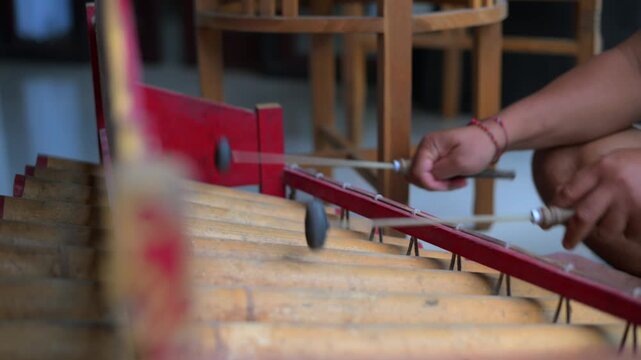 Traditional Balinese musician playing bamboo rindik gamelan