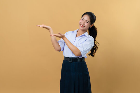 Young Asian woman in Thai student uniform presenting something on her open palm