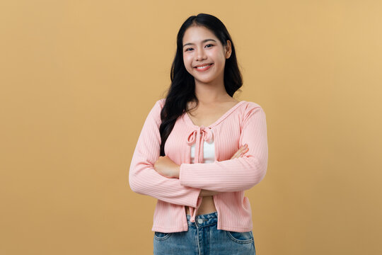 Proud Asian woman standing with arms crossed and smiling