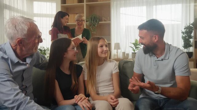 Dad Sharing a Conversation With His Girls and Their Grandfather Indoors