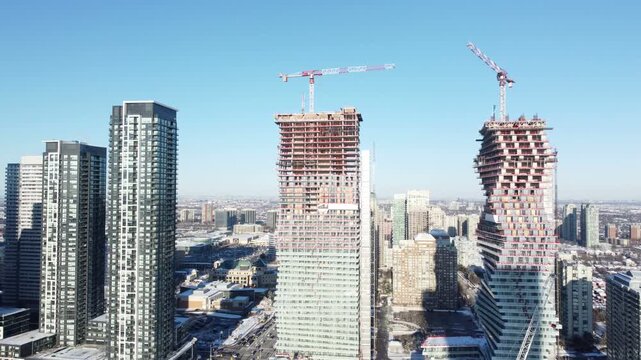 Condominiums under construction in downtown Mississauga, Ontario, Canada. Aerial, shot with a drone moving left, on a winter afternoon in December, 2021.