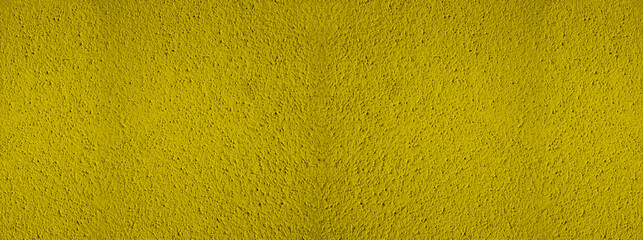 Fototapeta premium Background of natural yellow gold golden stucco in plaster cement texture lined pattern or stone in colors aged Textured illuminated wall fence surface blend of warm sunny tones backdrop.