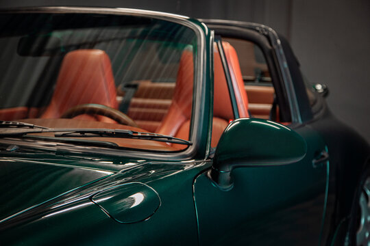 Green classic sports car interior with orange leather seats