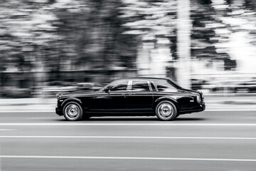 Fototapeta premium Luxury car speeding on city road with motion blur
