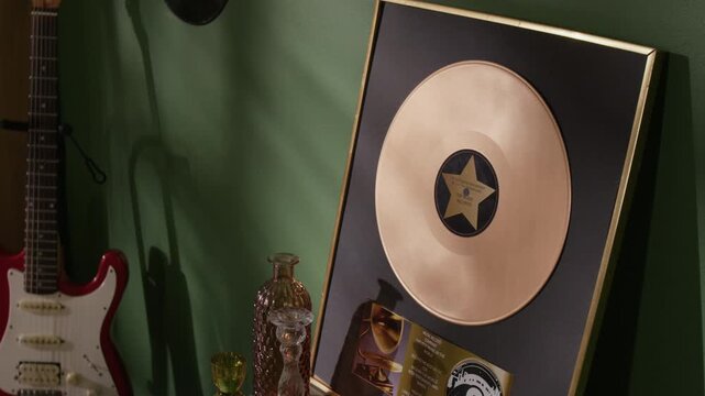 Close up shot of framed gold award plaque placed on shelf in music artists apartment displaying high commercial success