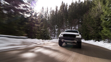 White pickup truck driving fast on snowy winter road © Chris M