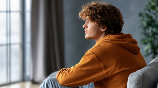 Dark room, man on sofa, blue news glow. Absorbed in TV, alone, digitally disconnected media consumer