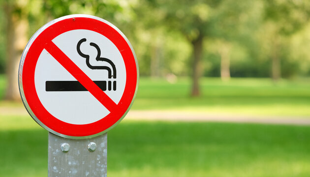 No Smoking Sign in a Public Park with Blurred Green Background