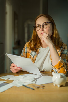 Cost of living crisis concept with worried woman counting coins at home