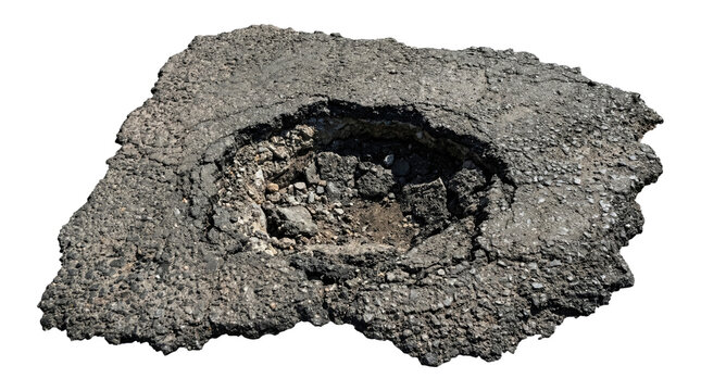 Large crumbling asphalt pavement slab with a deep circular pothole filled with gravel and dirt