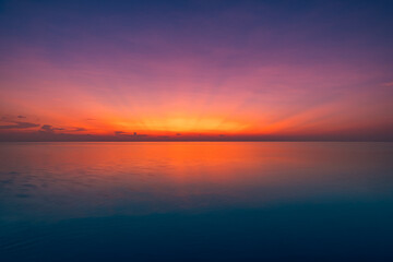 Obraz premium Dramatic deep red sunset ocean stunning breathtaking dreamy serene paradise exotic coastal island seascape destination summer vacation idyllic romantic. Twilight intense vivid colorful horizon sunrise