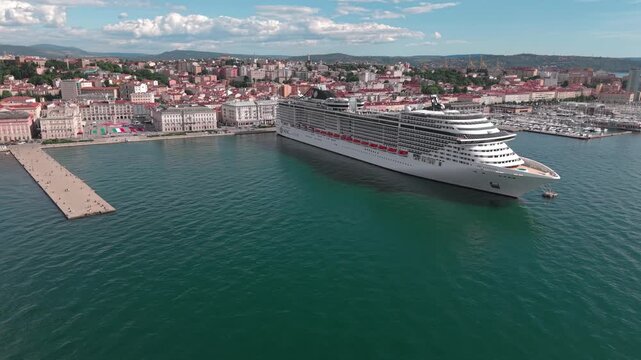 TRIESTE, ITALIA - 21 MAGGIO 2026: Veduta aerea della nave da crociera MSC FANTASIA ormeggiata alla Stazione Marittima con lo sfondo del panorama cittadino