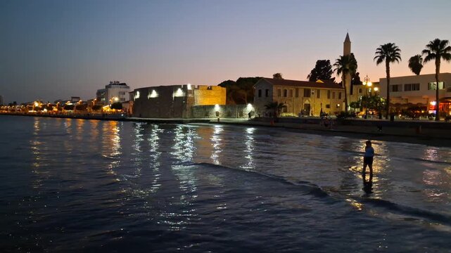 Larnaca Castle and the Minaret of the Djami Kebir Mosque alongside the mediterranean sea at dusk.