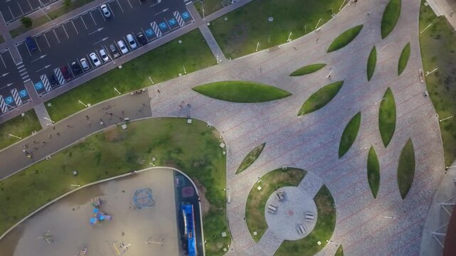 Aerial top-down view of some skaters moving on green lawn at central parck in Manta, Ecuador.