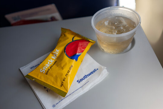 San Jose, CA, USA - May 6, 2022: Snack mix and iced ginger ale on a seat back tray table on a Southwest Airlines flight from San Jose (SJC) to Santa Ana (SNA).